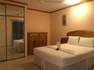 a bedroom with two beds and a mirror at Fond Bay Suites Hotel - Breathtaking Ocean Views in Micoud