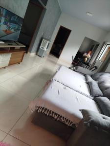 ein Wohnzimmer mit einer Couch und einem Teppich auf dem Boden in der Unterkunft Casa refúgio da paz in Pirenópolis + 21 Fotos