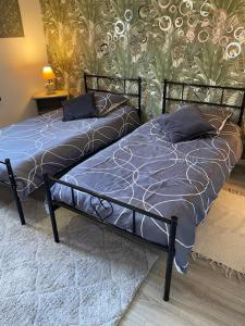 a bedroom with two beds with blue comforter at Charmant Logis a la campagne in Ardentes