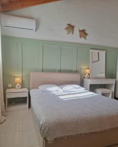 a bedroom with a bed with two tables and two lamps at Holiday House 'To Abeli' in Lithakia +34 photos