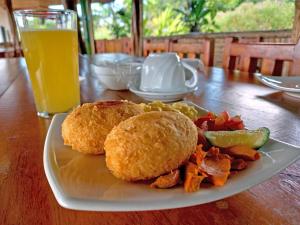 CotundoにあるSacha Waysaのサンドイッチと野菜のプレートとオレンジジュースのグラス