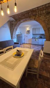 a kitchen and living room with a white table and chairs at Sa meraviglia in Posada