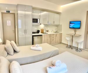 um quarto de hotel com duas camas e uma cozinha em The Corfu Urban Stays em Ágios Rókkos