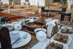 a table with plates of food on a table at Merzouga King Luxury Camp in Merzouga +18 photos