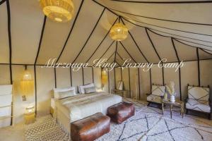 a bedroom with a bed in a tent at Merzouga King Luxury Camp in Merzouga