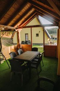 a patio with a table and chairs in a house at Vikendica Buzadzija M&N in Piskavica