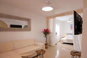 a living room with a white couch and a mirror at Sand & Beach in Pájara