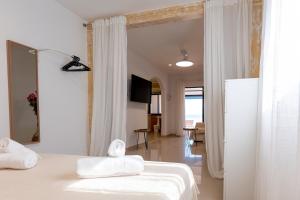 a bedroom with a bed with white sheets and a mirror at Sand & Beach in Pájara +17 photos