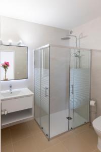a bathroom with a glass shower and a sink at Sand & Beach in Pájara +18 photos