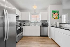 a kitchen with white cabinets and a stainless steel refrigerator at Modern 3BR Stay with Large Parking Pet Friendly in Killeen