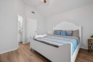 a white bed with blue pillows in a bedroom at Modern 3BR Stay with Large Parking Pet Friendly in Killeen