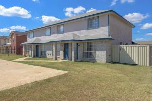 a brick house with a blue door on a yard at Modern 3BR Stay with Large Parking Pet Friendly in Killeen