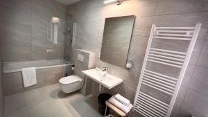 a bathroom with a sink and a toilet and a mirror at Eda7 Boutique Rooms in Sarajevo +37 photos