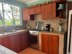 une cuisine avec des armoires en bois et un four à plaques de cuisson dans l'établissement Family Stay Desayuno, à Fátima