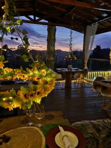 eine Terrasse mit einem Tisch und Blumen auf einer Terrasse in der Unterkunft Pousada Recanto dos Moinhos - Panorâmica in Campos do Jordão