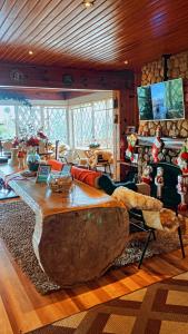 ein Wohnzimmer mit einem großen Sofa und einem Tisch in der Unterkunft Pousada Recanto dos Moinhos - Panorâmica in Campos do Jordão + 85 Fotos