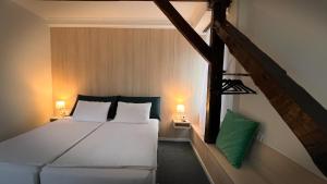 a bedroom with a white bed and two lamps at Eda7 Boutique Rooms in Sarajevo