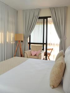 um quarto com uma cama, um sofá e uma janela em Pousada Estrela Mares em Guarda do Embaú