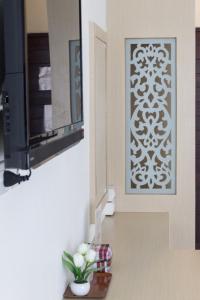 Cette chambre dispose d'une télévision et d'un mur avec une photo. dans l'établissement Crystal Nongkhai Hotel, à Nong Khai