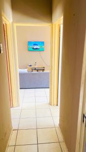 a hallway with a table and a tv on the wall at Serene Guesthouse in Manzini