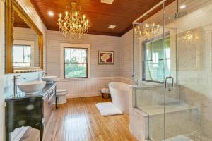 a bathroom with two sinks and a tub and a chandelier at Kimball Castle Legacy - Lake Views - Near Gunstock in Gilford