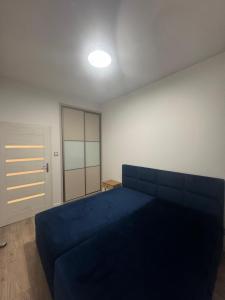 een slaapkamer met een blauw bed in een kamer bij Apartament in Skorka