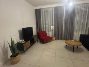 een woonkamer met een rode stoel en een televisie bij Apartament in Skorka