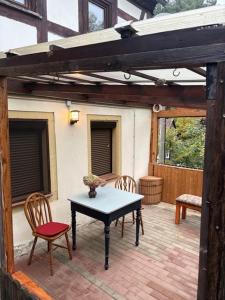 eine Terrasse mit einem Tisch und Stühlen auf einer Backsteinterrasse in der Unterkunft Kleines gemütliches Fachwerkhaus für vier Gäste in Reinhardtsdorf