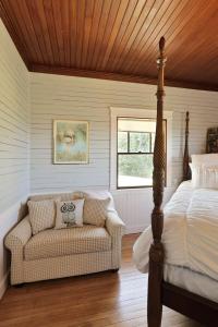 a bedroom with a bed and a couch and a window at Kimball Castle Legacy - Lake Views - Near Gunstock in Gilford