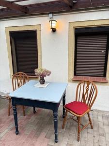 einen blauen Tisch mit zwei Stühlen und eine Vase mit Blumen in der Unterkunft Kleines gemütliches Fachwerkhaus für vier Gäste in Reinhardtsdorf