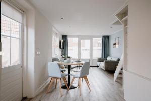een eetkamer en woonkamer met een tafel en stoelen bij Hotel Kodde in Aagtekerke