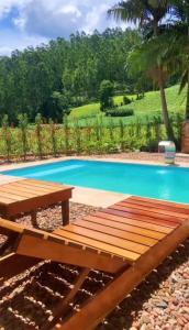 a wooden picnic table next to a swimming pool at Espaço Vitali in Blinha