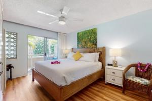 ein Schlafzimmer mit einem Bett und einem Fenster in der Unterkunft Salt & Palms at Plantation Hale E3 in Kapaa + 34 Fotos