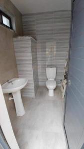 a bathroom with a toilet and a sink at Pleasant 3-bedroom in Praia City in Praia +8 photos