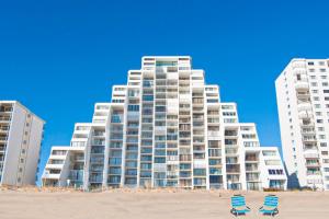 two chairs on the beach in front of a large building at Pyramid 9G in Ocean City