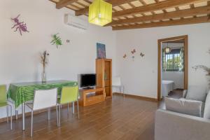 a living room with a table and chairs and a television at Casas con piscina compartidas Garaje y Wi-Fi in Roche +17 photos