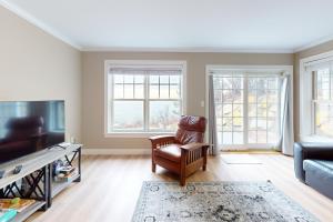 a living room with a chair and a tv at Summer Cape Escape in Dennis Port