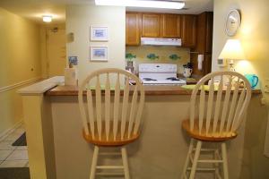 duas cadeiras sentadas num balcão numa cozinha em Sugar Beach 312 em Gulf Shores