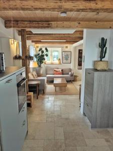 a kitchen and a living room with a couch at Cosy cottage in the countryside near Landsberg in Schwifting