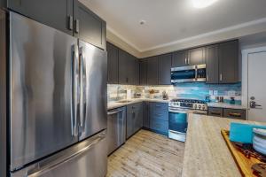a kitchen with blue cabinets and a stainless steel refrigerator at Ocean Peace in Dennis Port