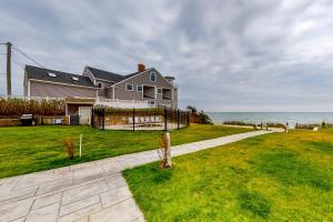 a house on the beach with the ocean in the background at Ocean Peace in Dennis Port