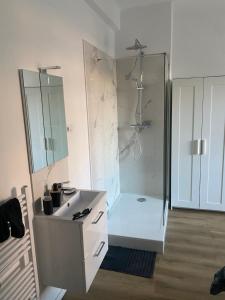 Un baño blanco con ducha y lavabo. en Comfort Zone, en Lenzburg