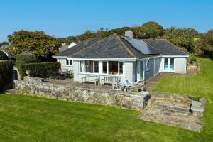 a white house with a stone wall in the yard at Peaceful country escape with garden & views in Mylor Bridge
