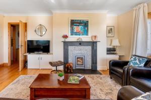 a living room with a couch and a fireplace at Peaceful country escape with garden & views in Mylor Bridge