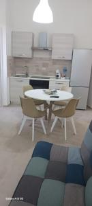 una cucina con un tavolo e sedie in una stanza di Cappuccini room's a Caltagirone