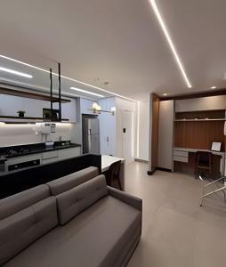 a living room with a couch and a dining room at Luxuoso Estúdio London - St Oeste - ID Vida Urbana in Goiânia