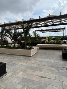a patio with a pavilion with palm trees and plants at Baltia departamento in Mérida