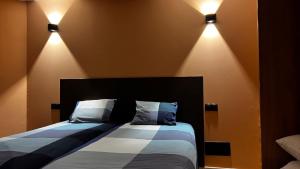 a bedroom with a bed with lights on the wall at Jacaranda stylish ambiance with volcano and ocean views in Tacoronte
