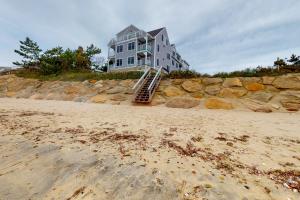 a house on the beach next to a building at Villa Balena - A Cape Cod Oasis in Dennis Port