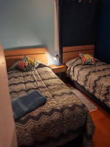 a bedroom with two beds and a pillow on it at Departamento 4 prs San pedro de la paz in San Pedro de la Paz +2 photos